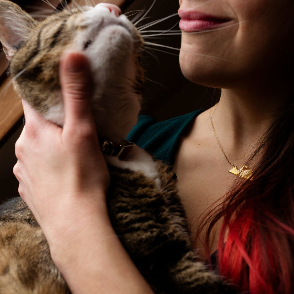 MoutainDino_Fenris Collier dinosaure finition or porté avec gros chat - Les Naturalistes bijoux