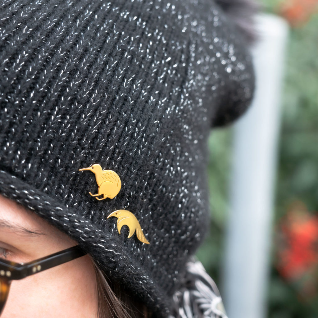 pins_bonnet Pins tamanoir et pins kiwi finition or portés sur un bonnet Les Naturalistes bijoux
