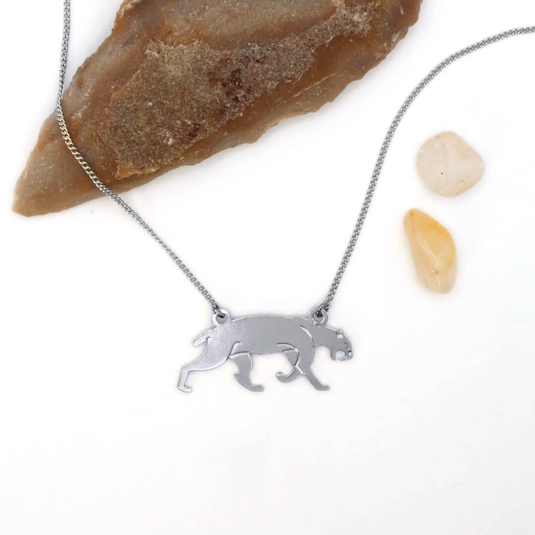 Collier smilodon en laiton argenté — collection Préhistoire — fond blanc 01, Les Naturalistes