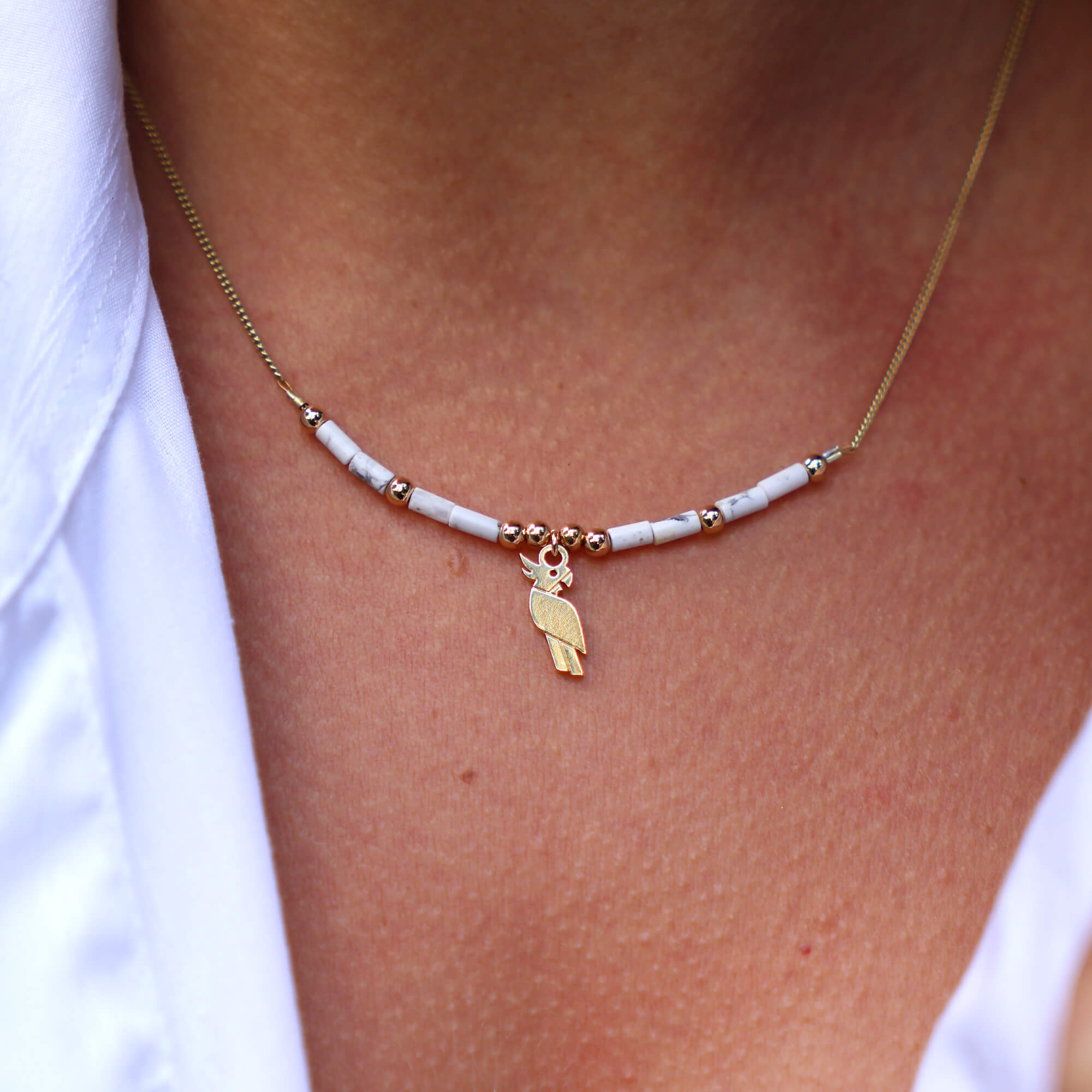 Collier horizon perroquet et howlite en laiton doré — collection Jungles et forêts — porté 01, Les Naturalistes